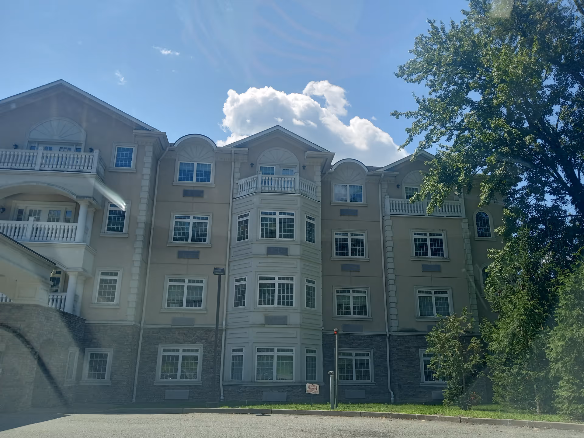 Front view of a multi-story senior living building with balconies