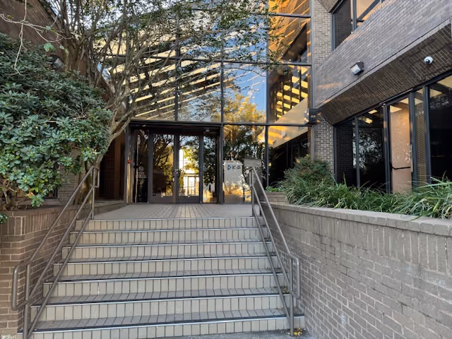 Brick building entrance with glass doors and wide concrete stairs