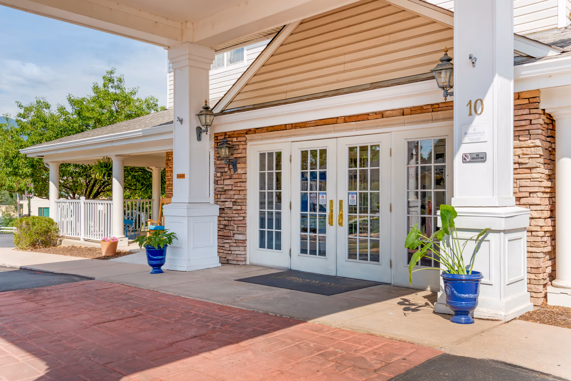 Front entrance of Brookdale Monument Valley Park with double doors, columns, and potted plants.