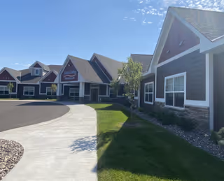 Curved driveway leads to a modern senior living facility with connected covered entrances.