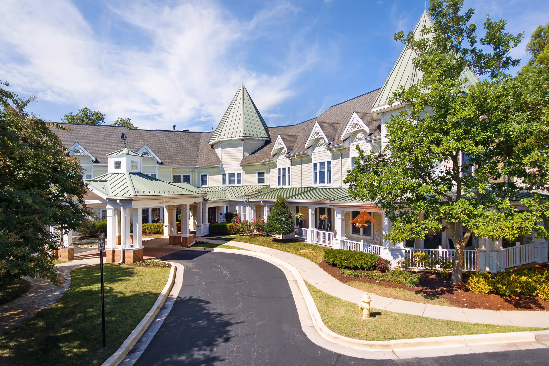 Sunrise of Annapolis exterior building with green metal roof and covered entrance.