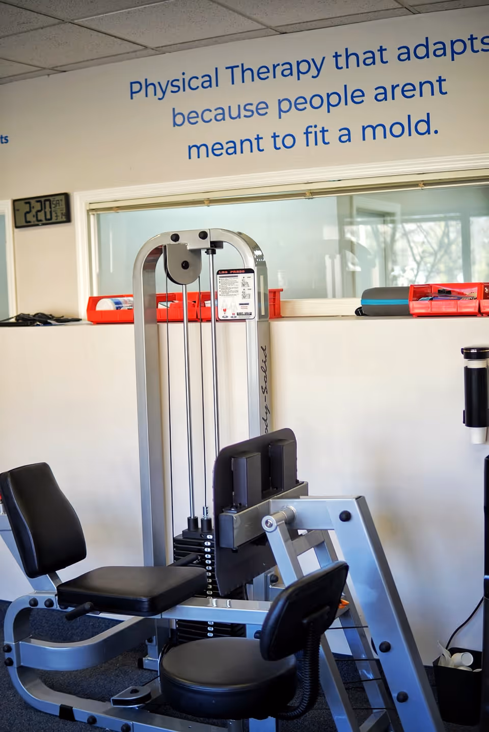 Senior facility gym with a weight machine and motivational wall quote.