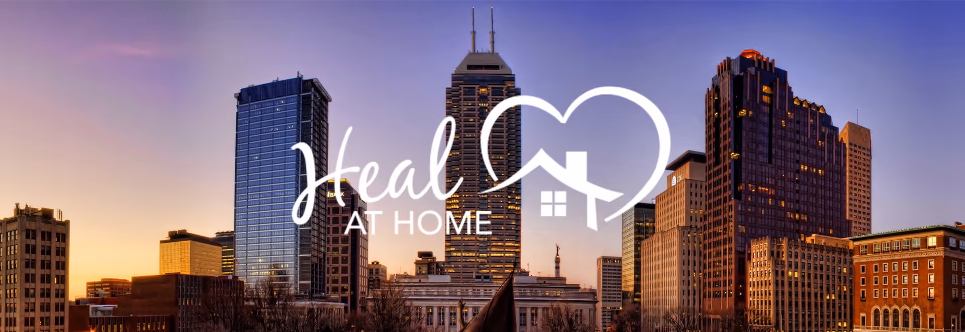 City skyline with a Heal at Home logo overlay on tall buildings at sunset.