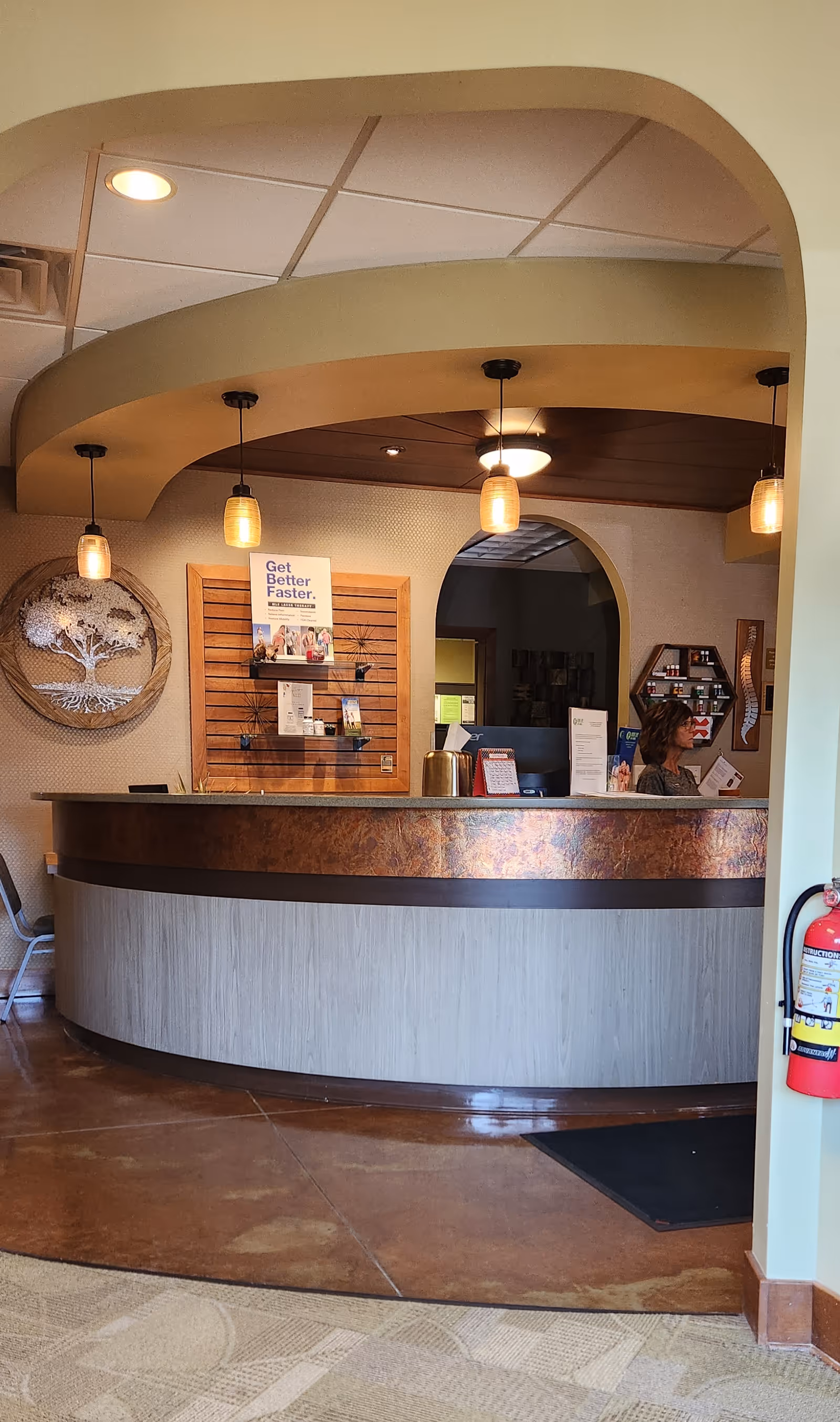 Curved reception desk with warm lighting greets visitors in a senior living lobby.