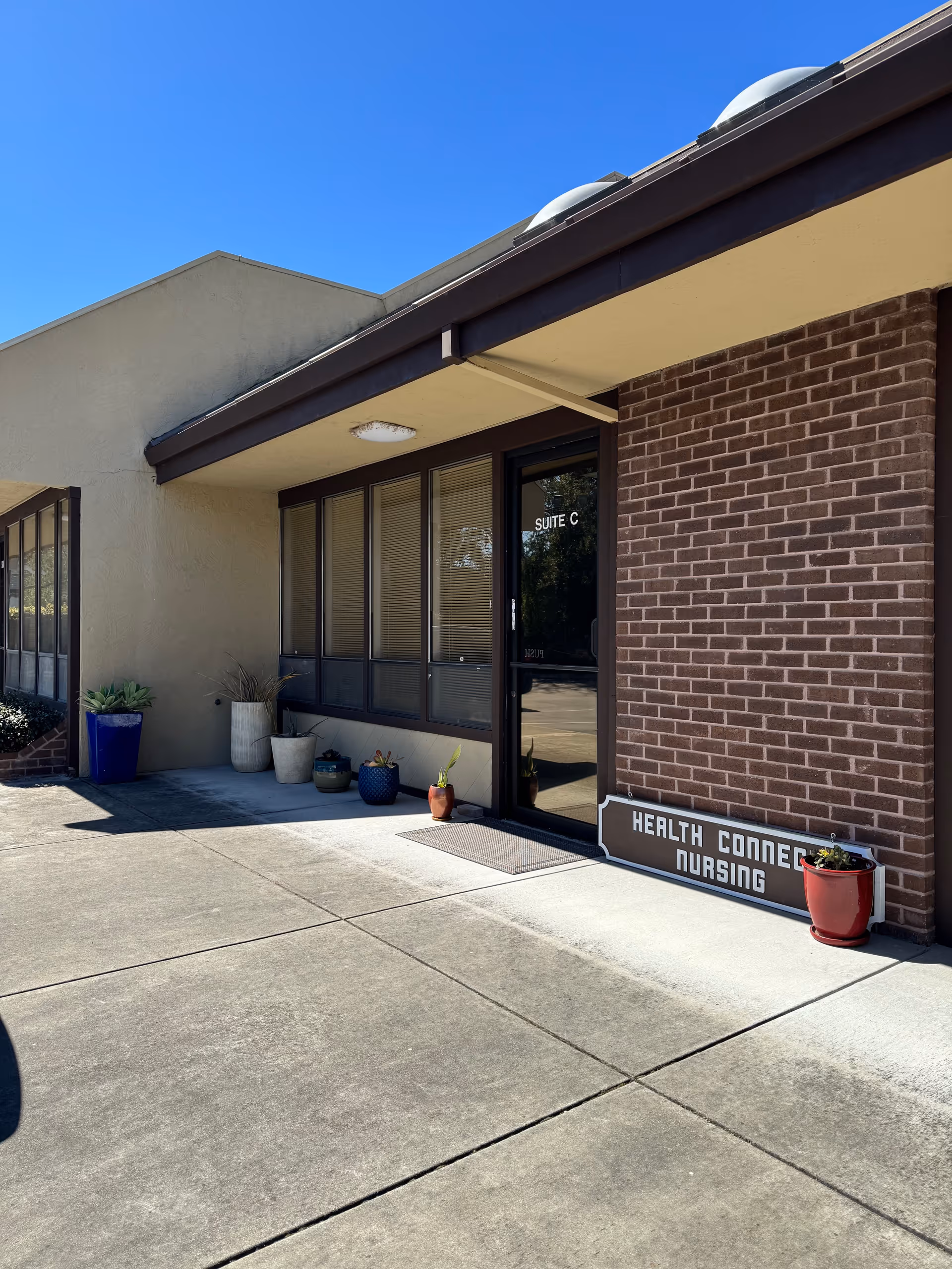 Front exterior of Health Connect Nursing with entrance and potted plants.
