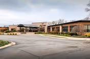 Exterior view of Avantara Evergreen Park facility with brick walls, entrance canopy, and landscaping.