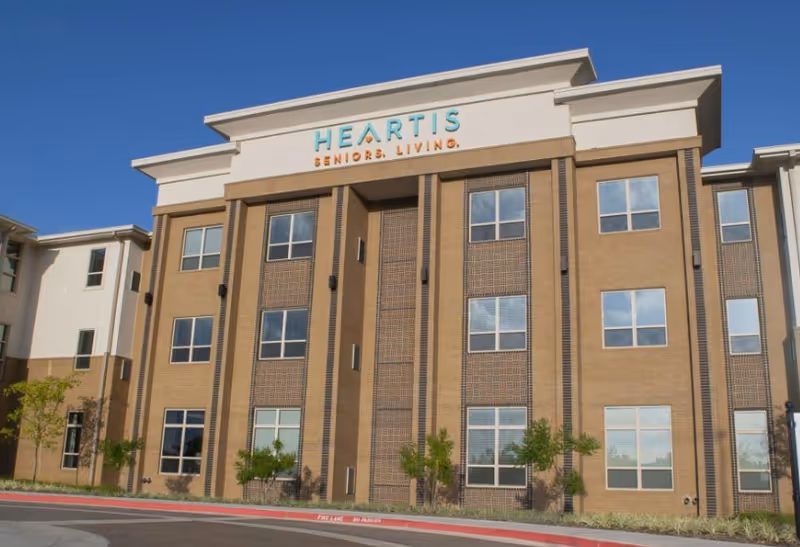 Exterior view of Heartis Senior Living building with brick facade and sign