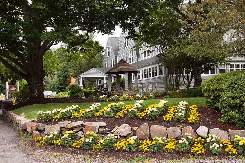 Sunrise of Weston exterior with landscaped flower beds and a stone-bordered lawn.