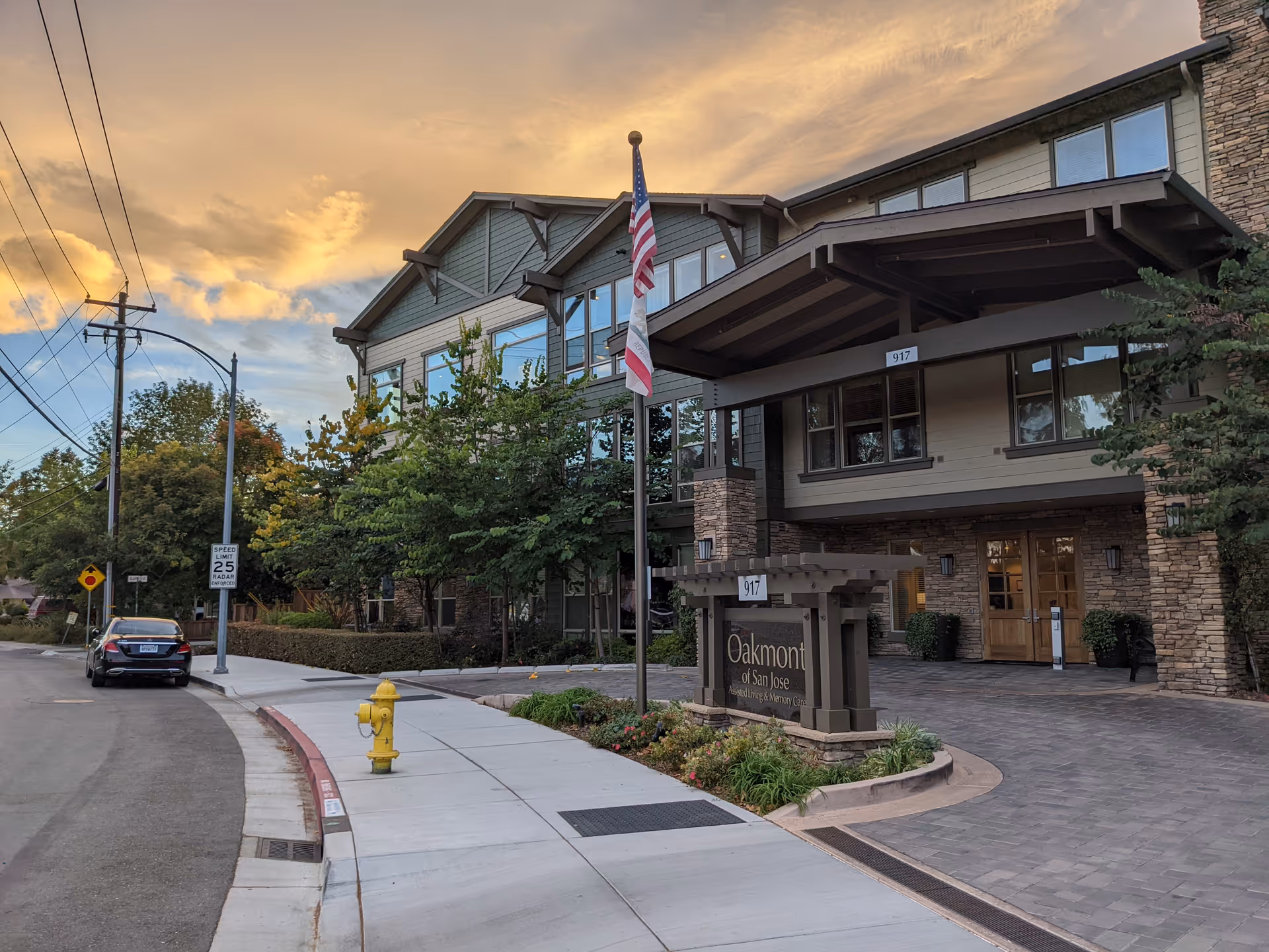 Exterior view of Oakmont of San Jose with entrance, flag, and landscaping.