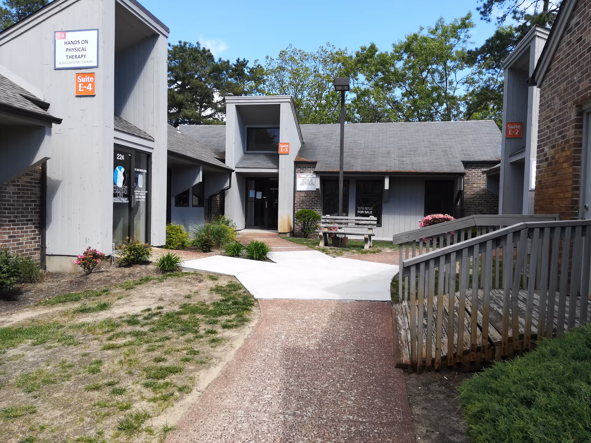 Exterior view of Summit Home Care facility with a walkway and bench.