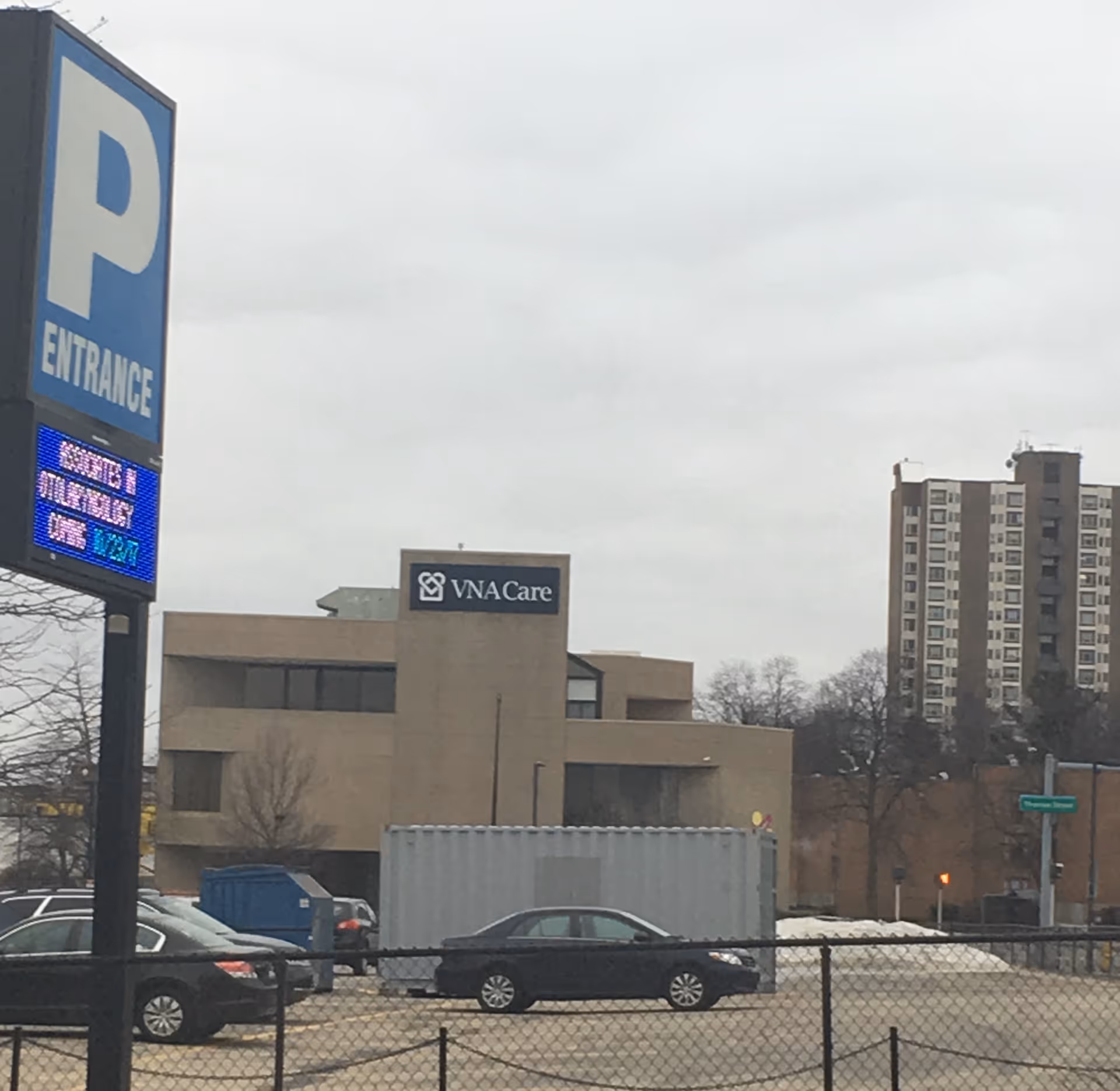 Exterior view of a VNA Care facility with parking lot and blue entrance sign.