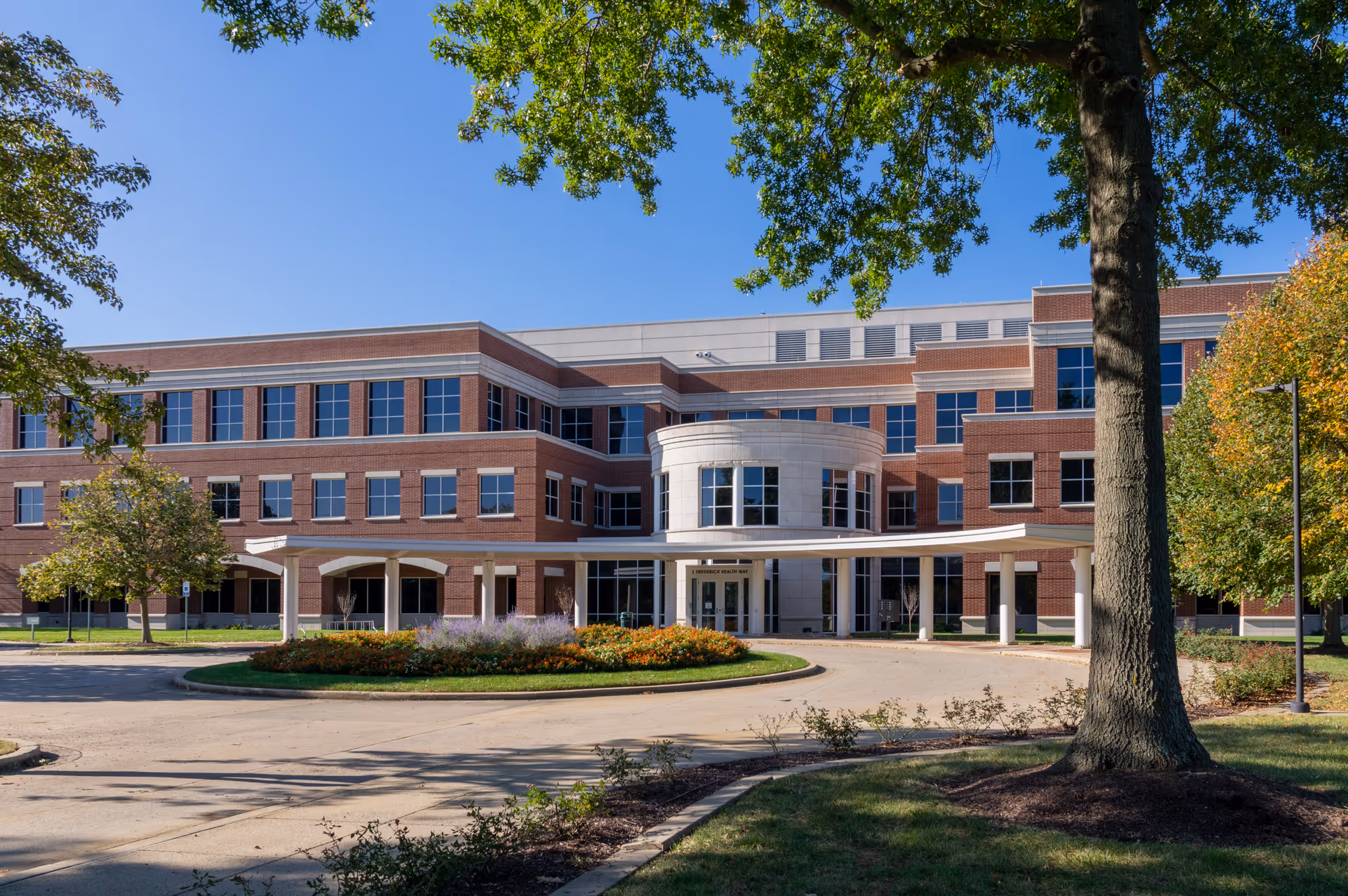 Front exterior of Frederick Health Hospice, a brick building with a circular driveway.