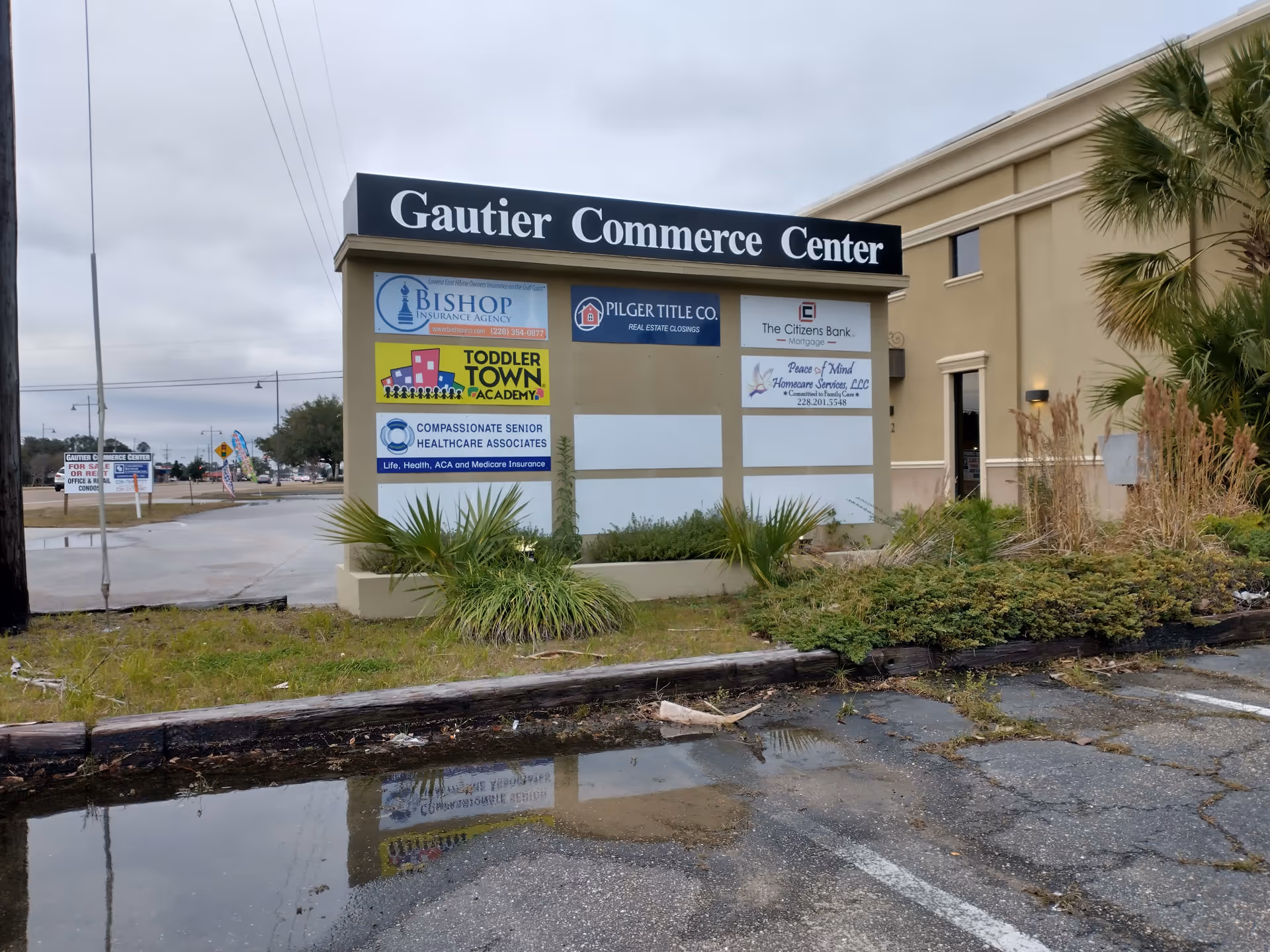 Exterior view of a building with a large sign and multiple business advertisements.