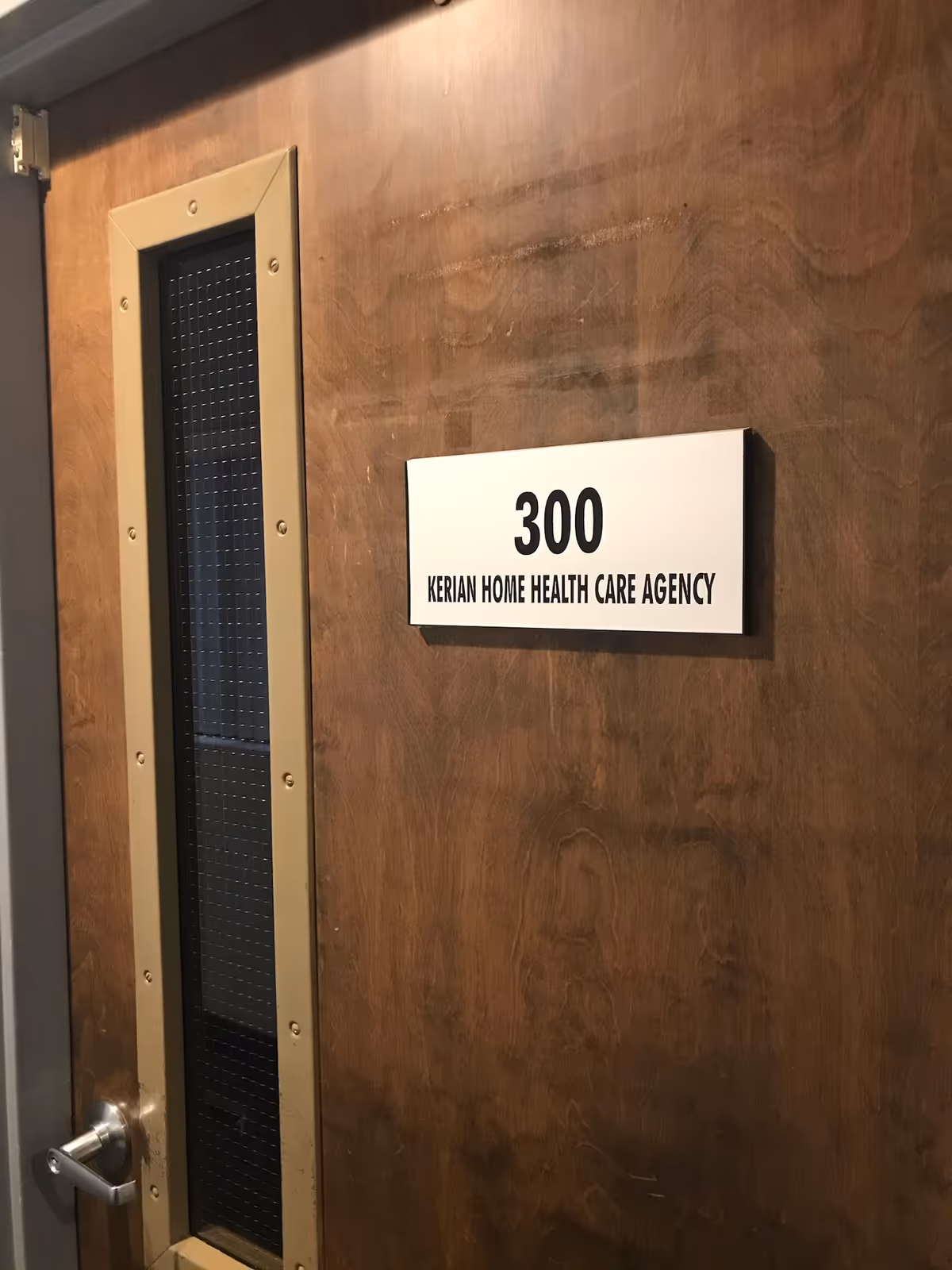 Wooden interior door with room number 300 and sign Kerian Home Health Care Agency