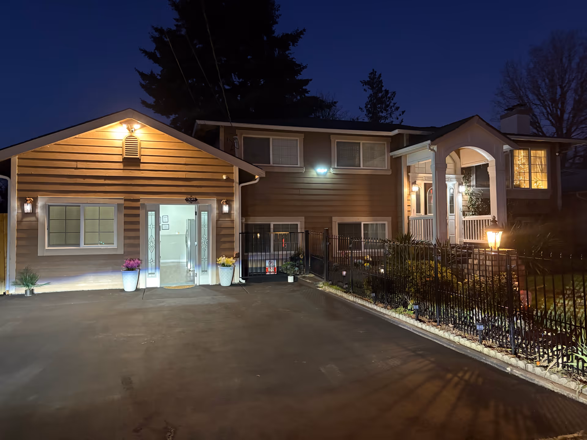 Nighttime exterior of Top Home Care senior living facility with lit entrances and fencing.