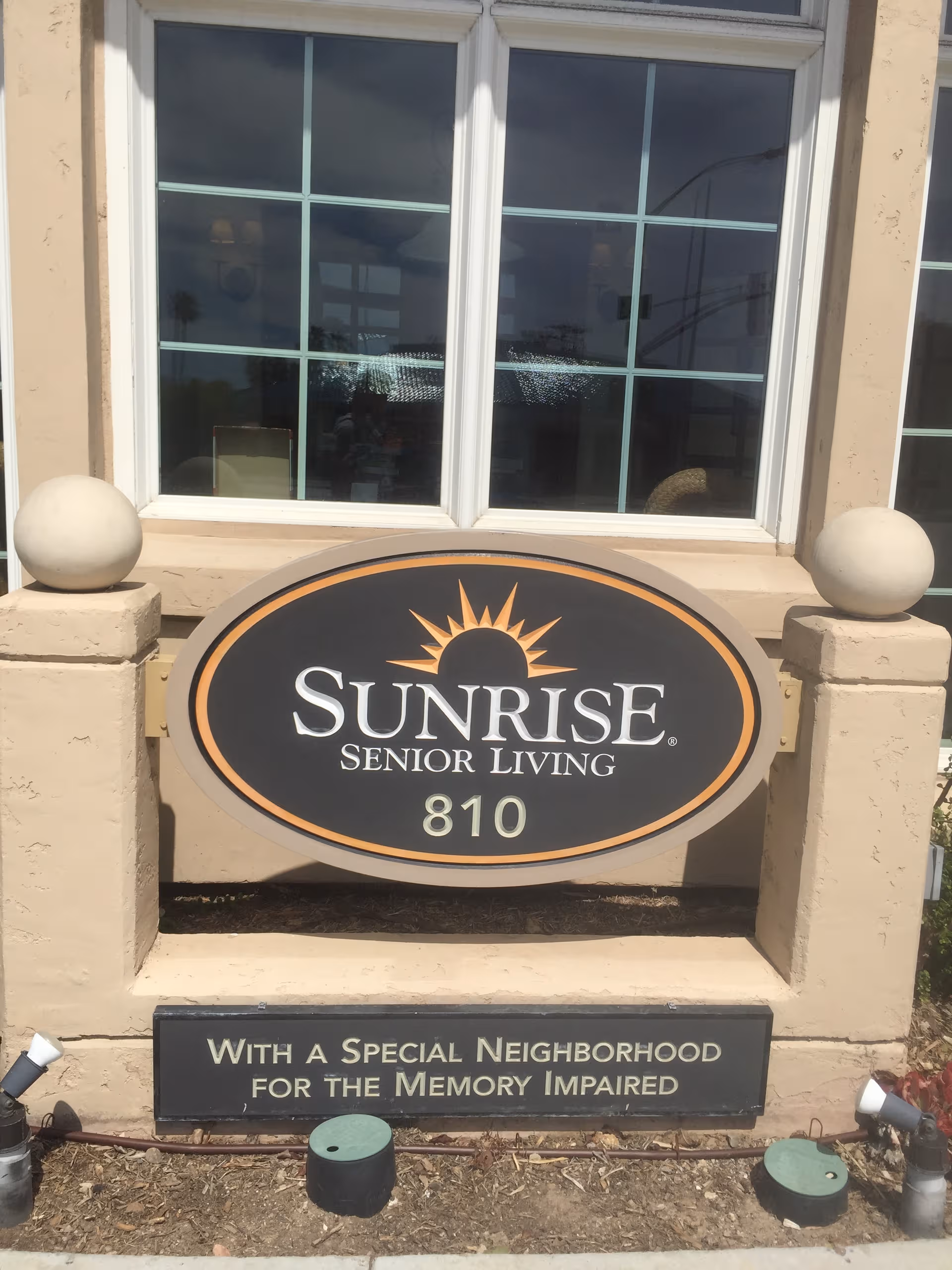 Exterior view of Sunrise Senior Living sign at Ivy Park La Jolla outside entrance.