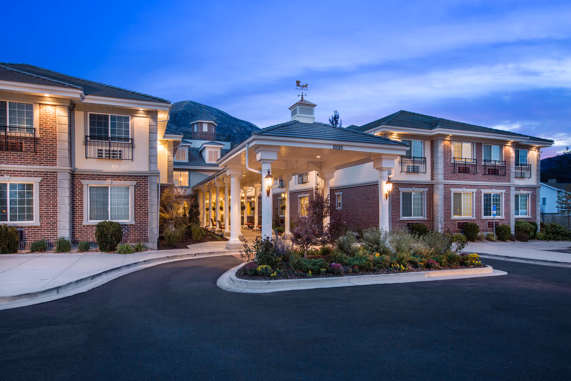 Exterior view of The Charleston at Cedar Hills, brick senior living building with covered entrance.