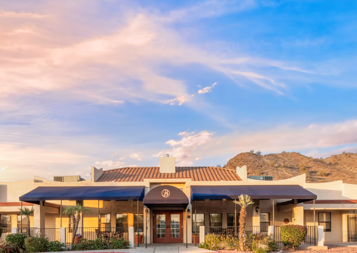 Exterior view of Bethesda Gardens with a covered entrance and desert landscape.