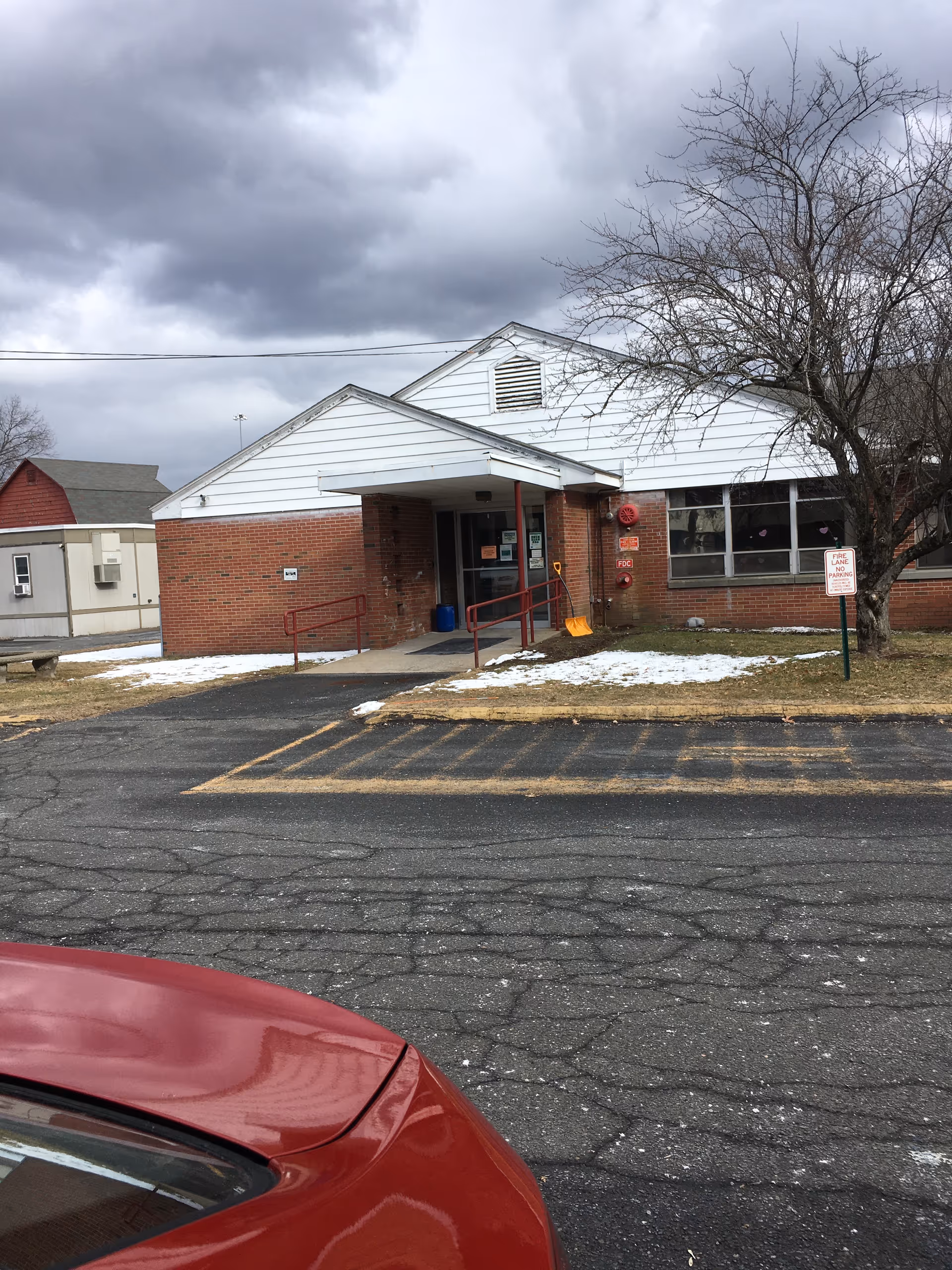 Exterior view of Chicopee Rehabilitation and Nursing Center entrance with ramp and snow patches.