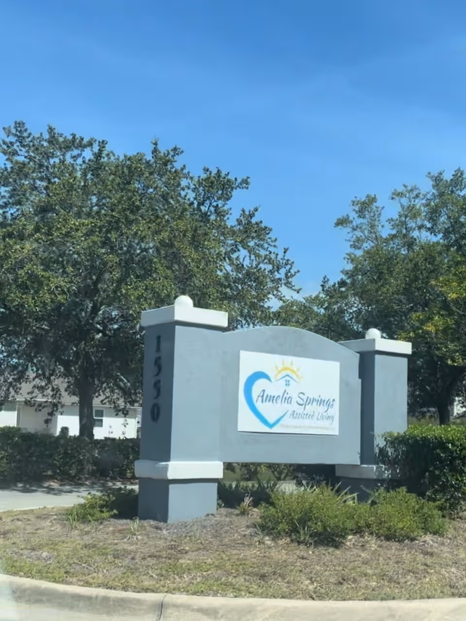Front exterior sign for Amelia Springs Assisted Living with blue heart logo