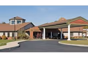 Front exterior of Woodbrook Assisted Living Residence with covered entrance and circular driveway.