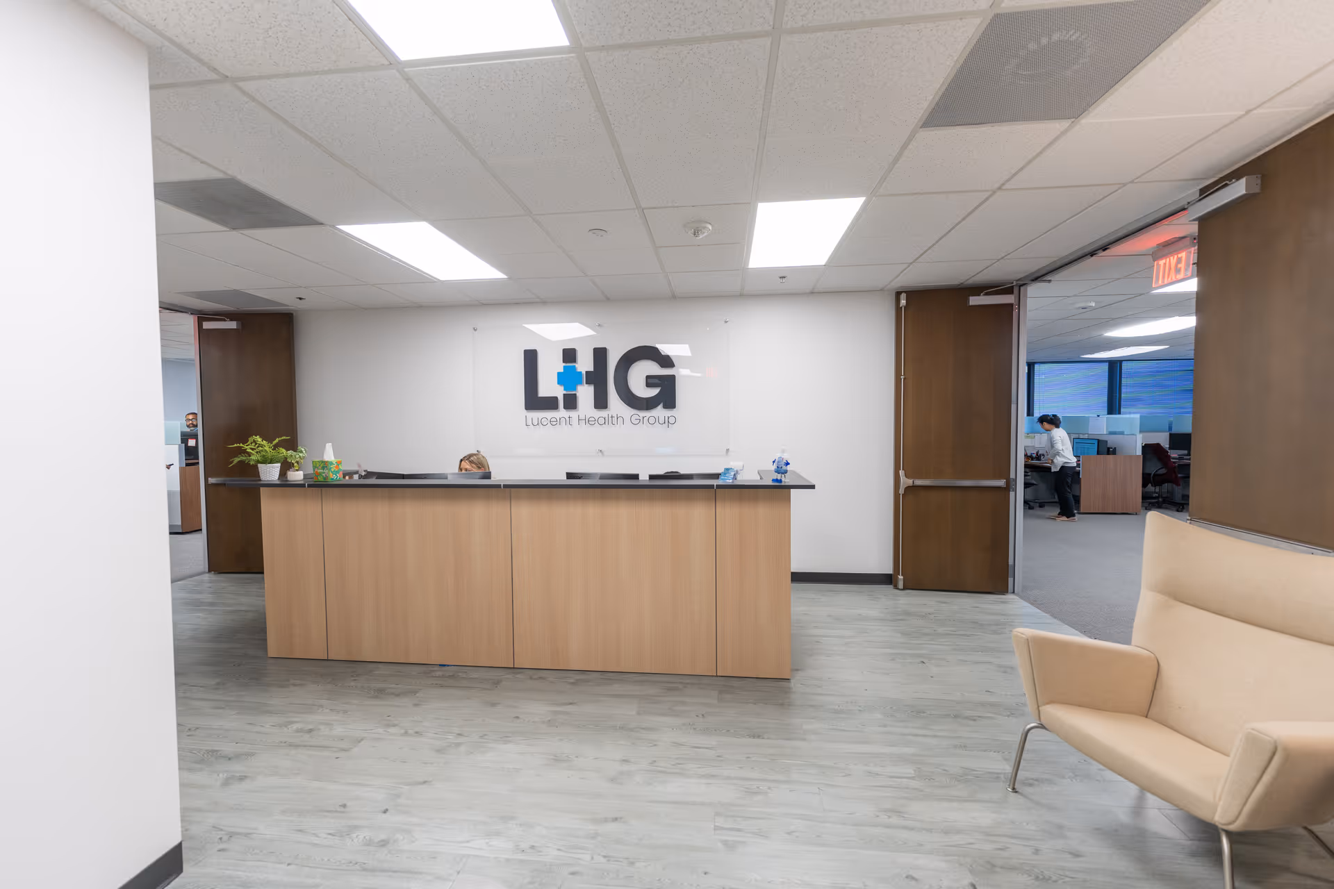 Reception desk in a Lucent Health Group lobby with seating and doorway.