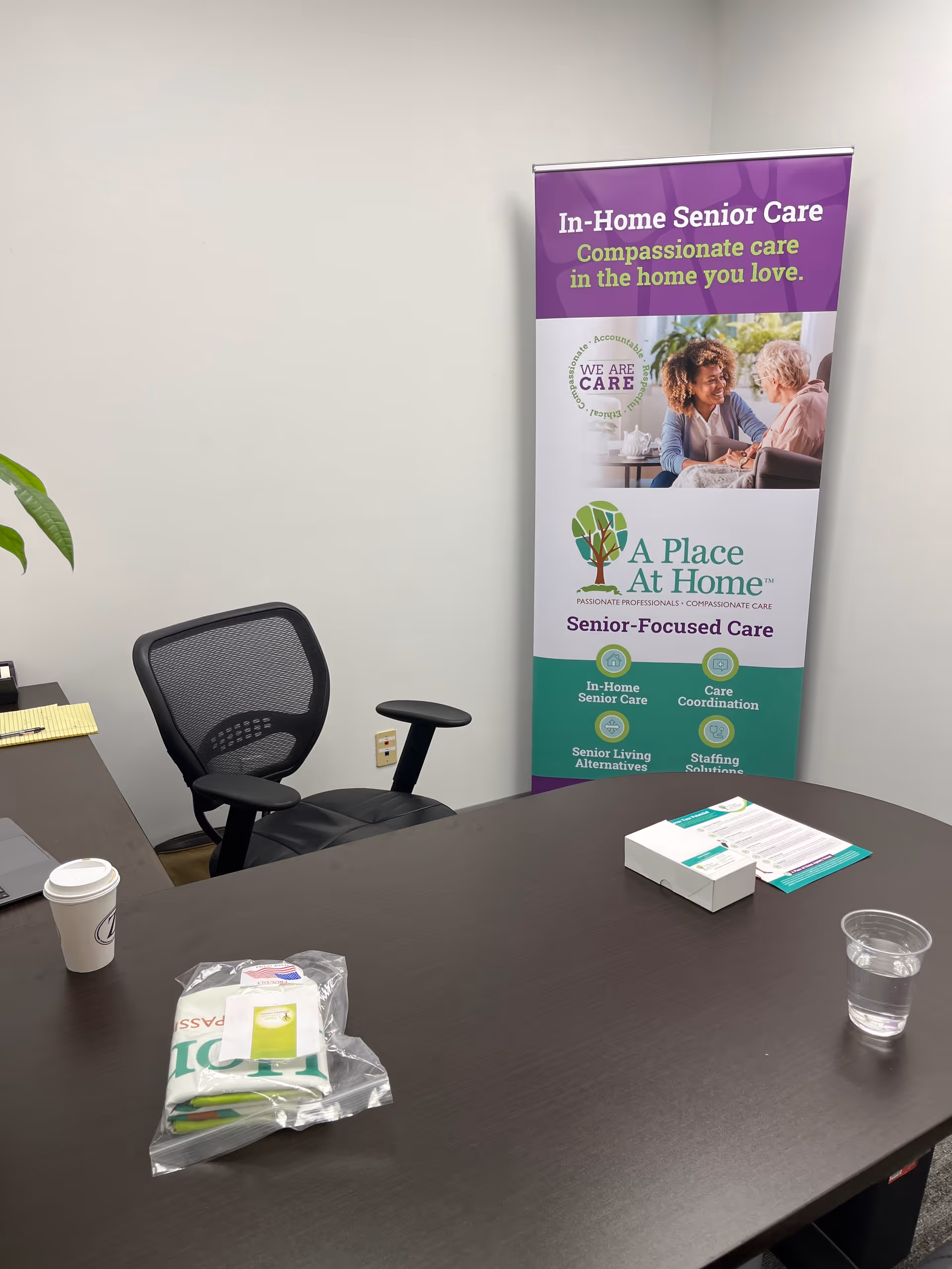 Office desk and chair beside a banner for A Place At Home - Fairfield South.