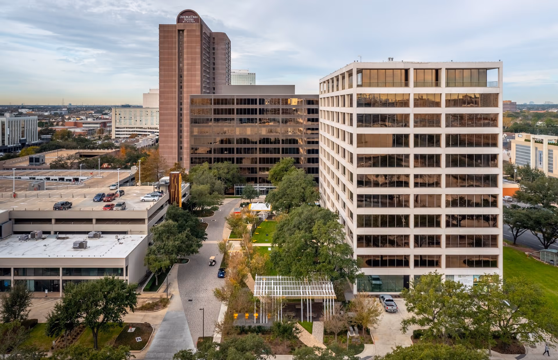 Aerial view of modern office buildings and green spaces in a cityscape.