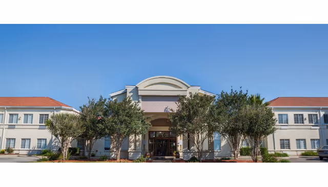 Esplanade Gardens senior living building facade with trees and a clear entrance.