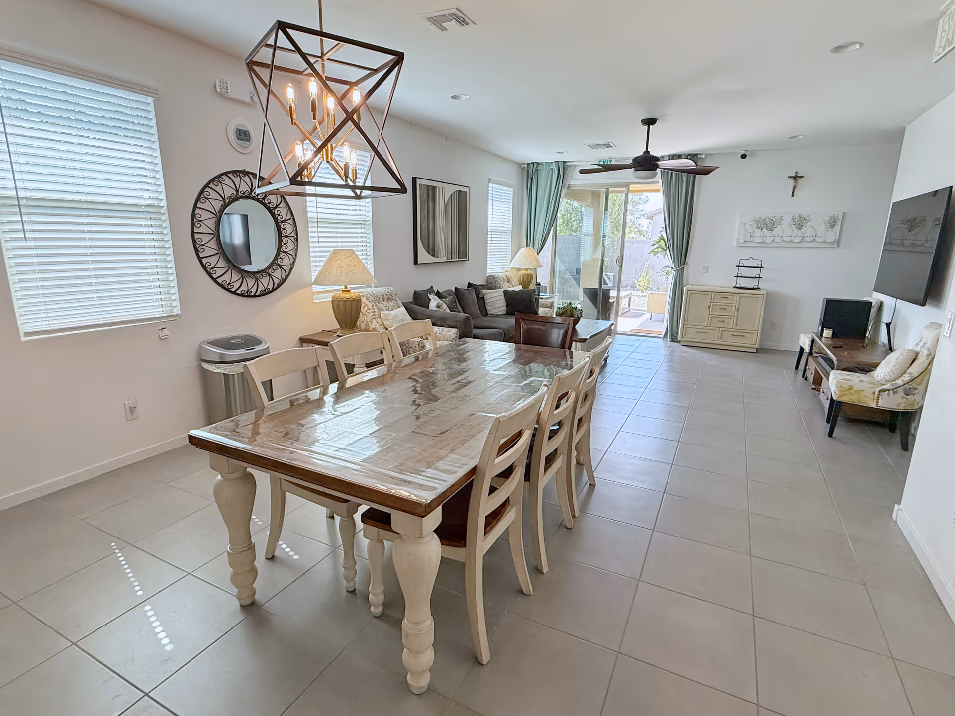 Spacious dining and living area with a long wooden table, chairs, and a view of outdoors.