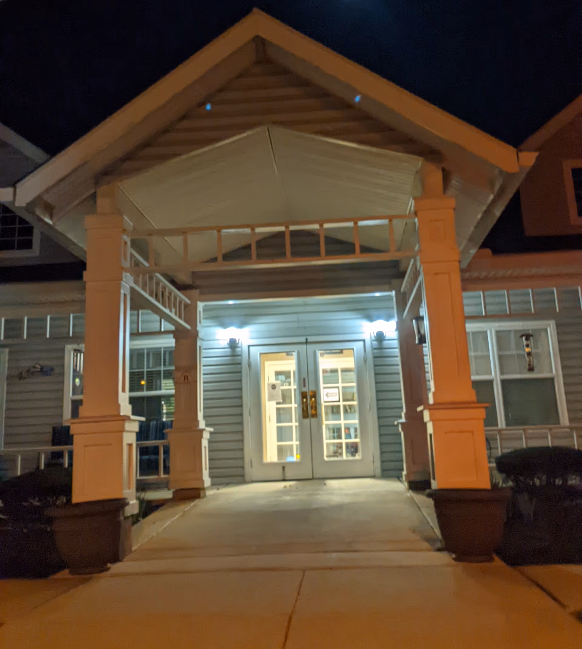 Night view of Summit Place entrance with lit double doors under a covered porch.