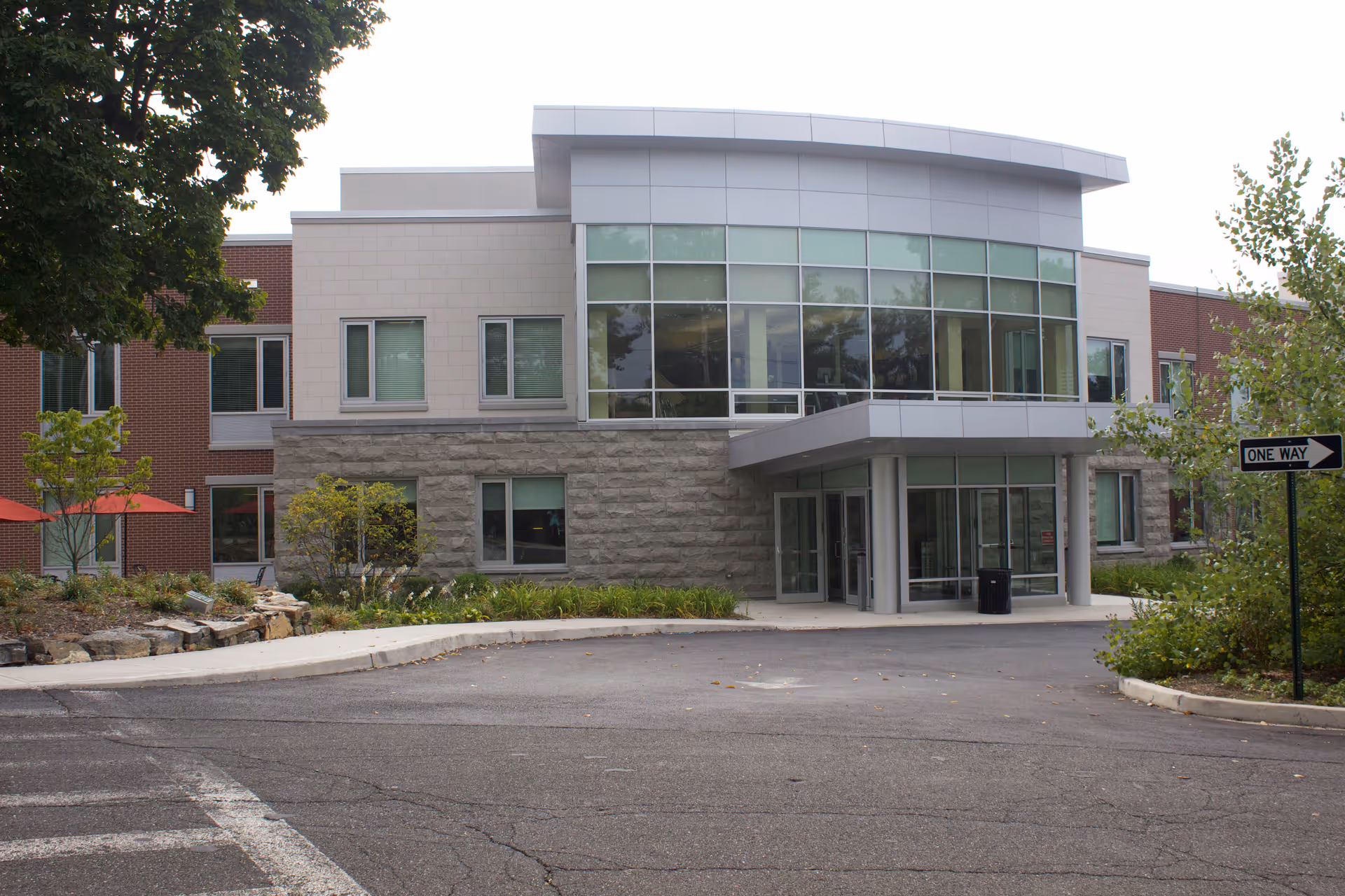 Exterior view of Wartburg Skilled Nursing Community building with glass entrance and driveway.