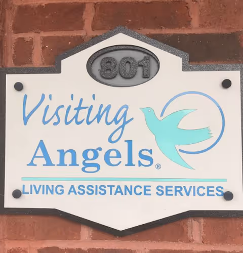 Sign on brick wall reading Visiting Angels Home Care with dove logo