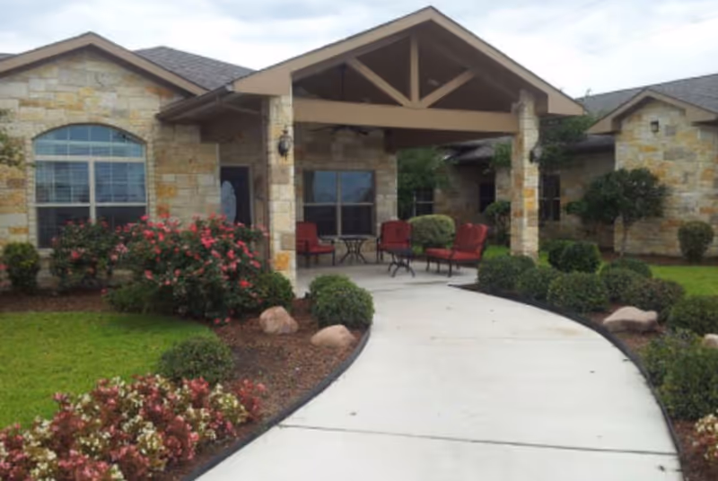 Canyon Creek Memory Care entrance with stone facade and red outdoor seating.