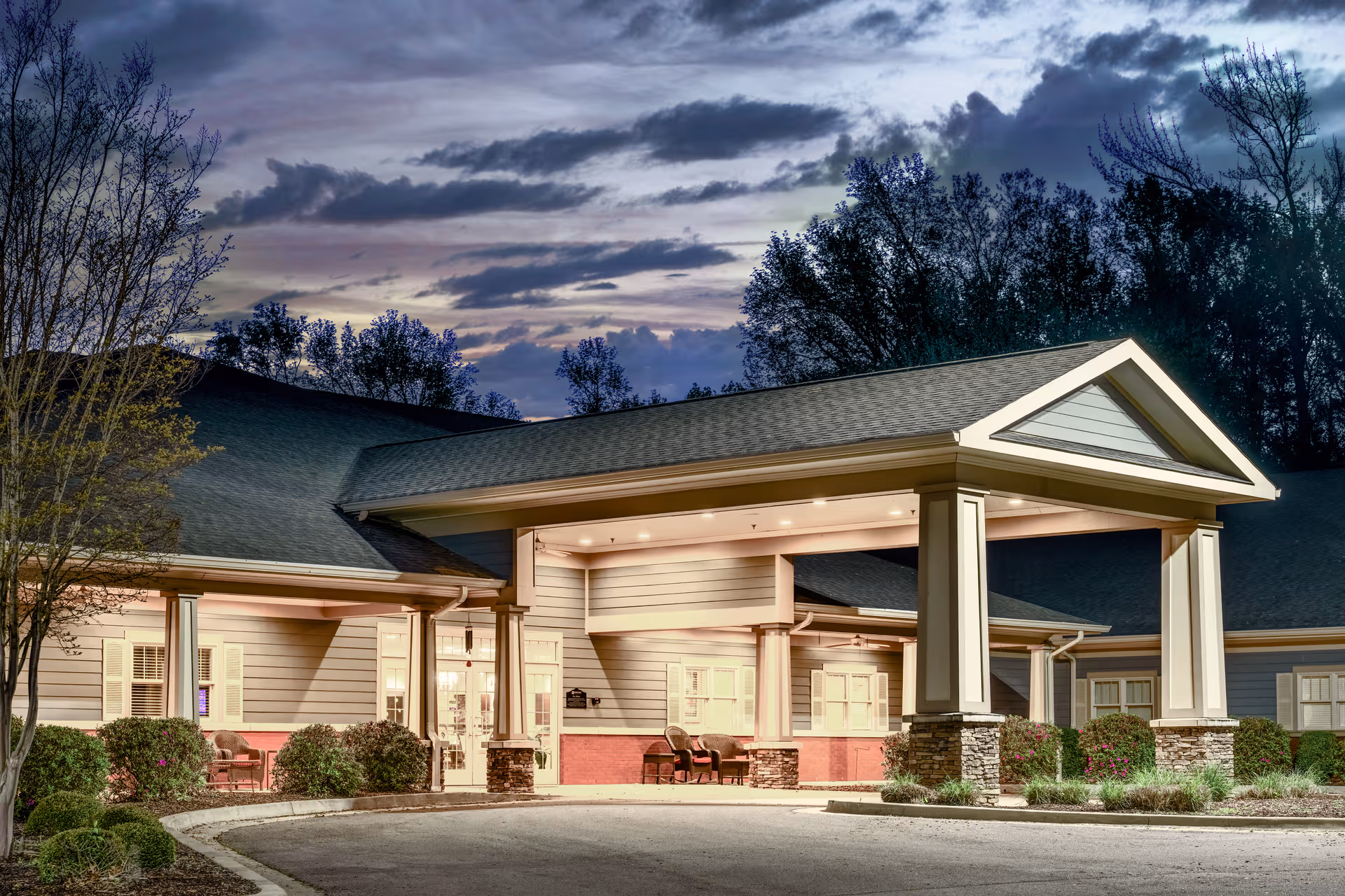 Exterior view of a memory care facility entrance with a covered porte-cochère.