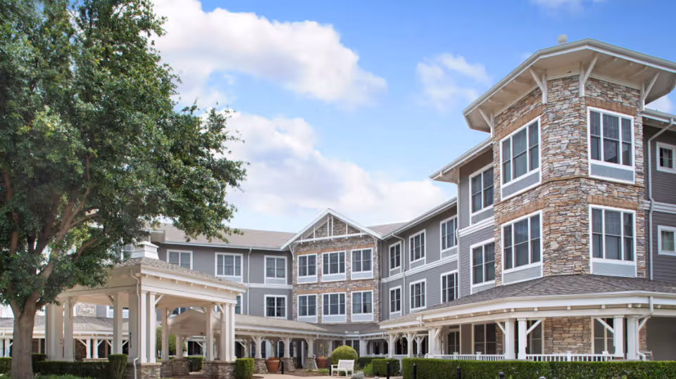 Sunrise of Plano exterior building with stone accents and shaded walkways.