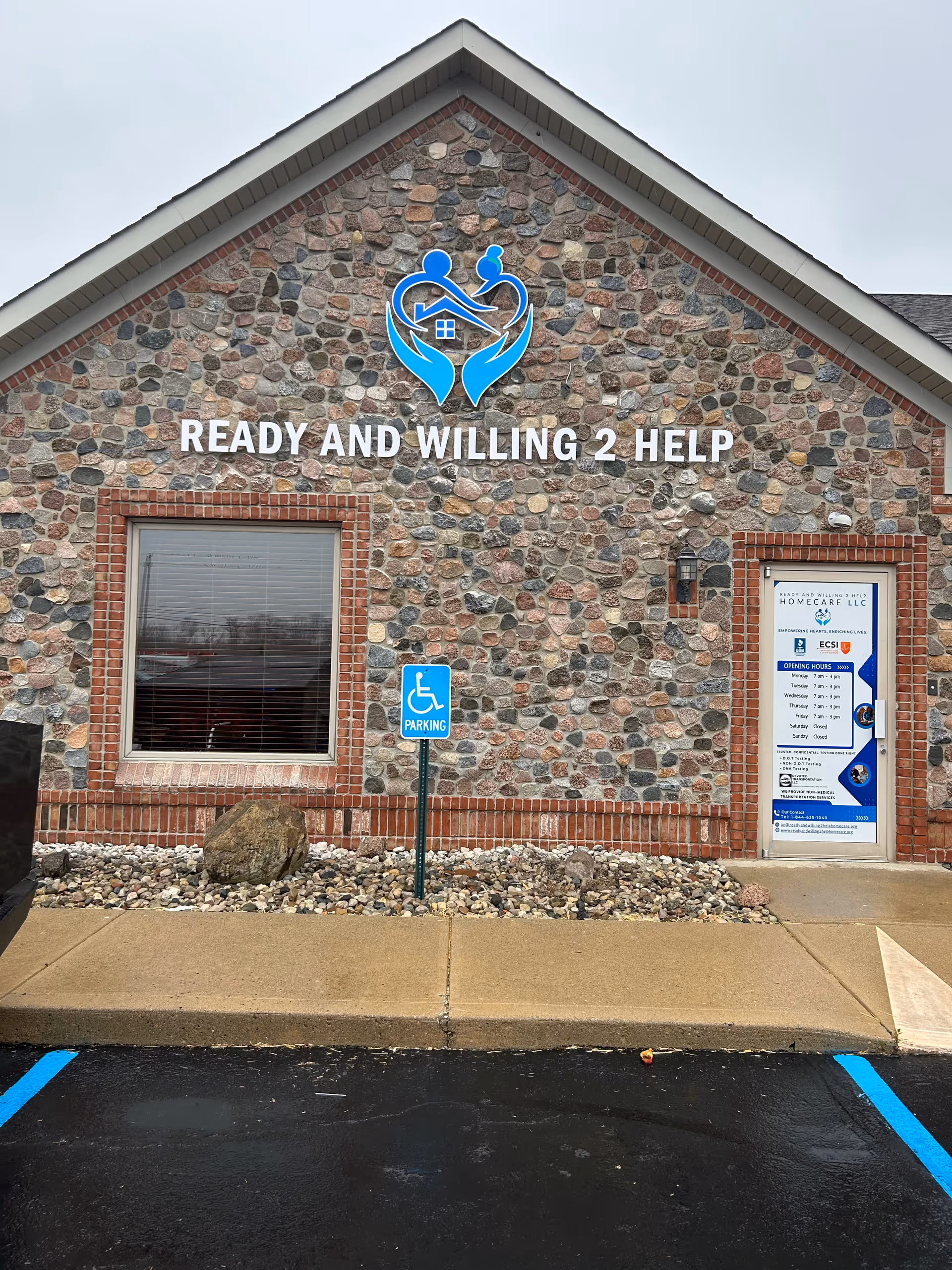 Stone exterior building with Ready And Willing 2 Help sign and handicap parking.