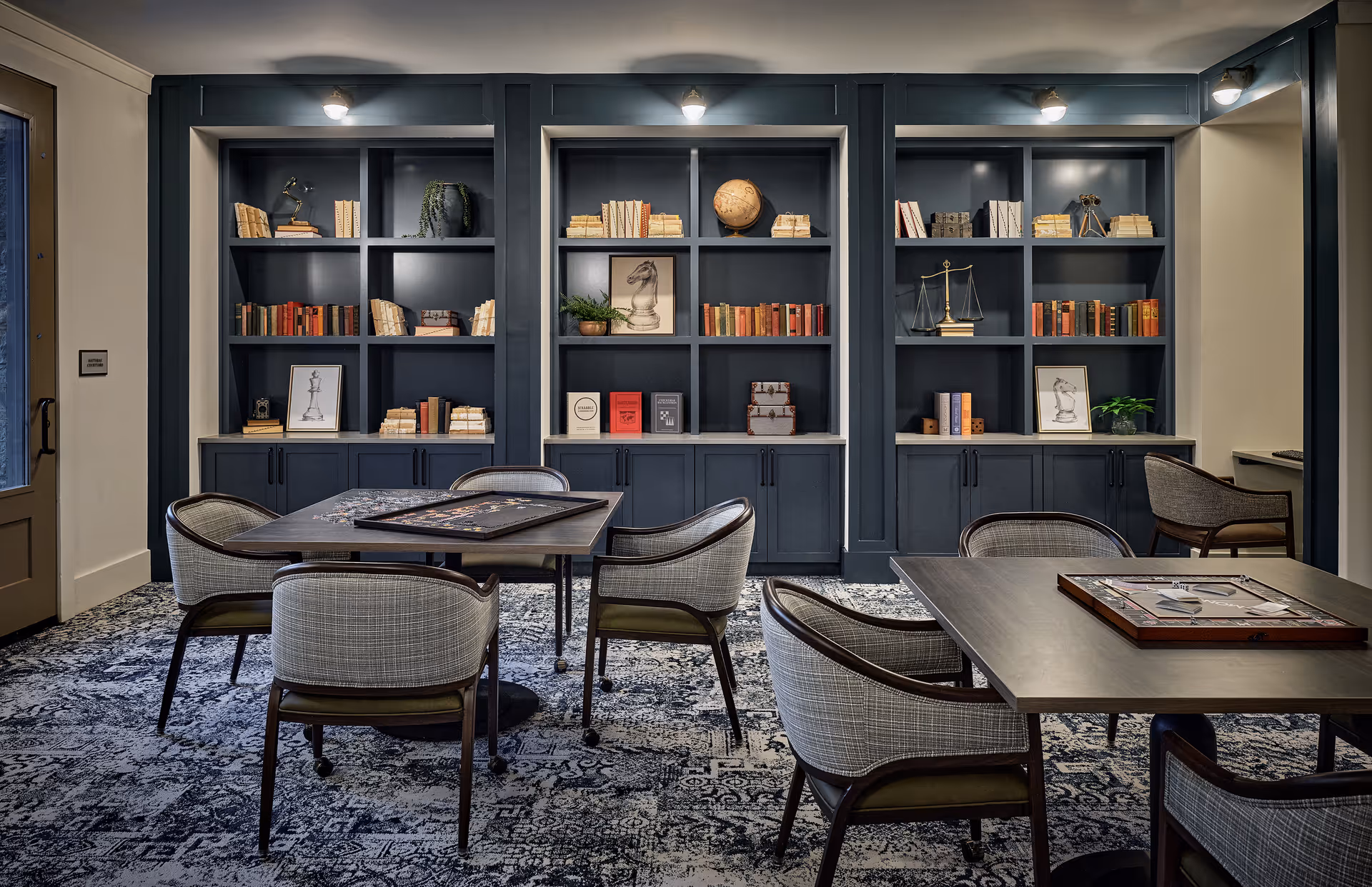 Waltonwood Lead Mine library lounge with dark built-in bookshelves and tables.