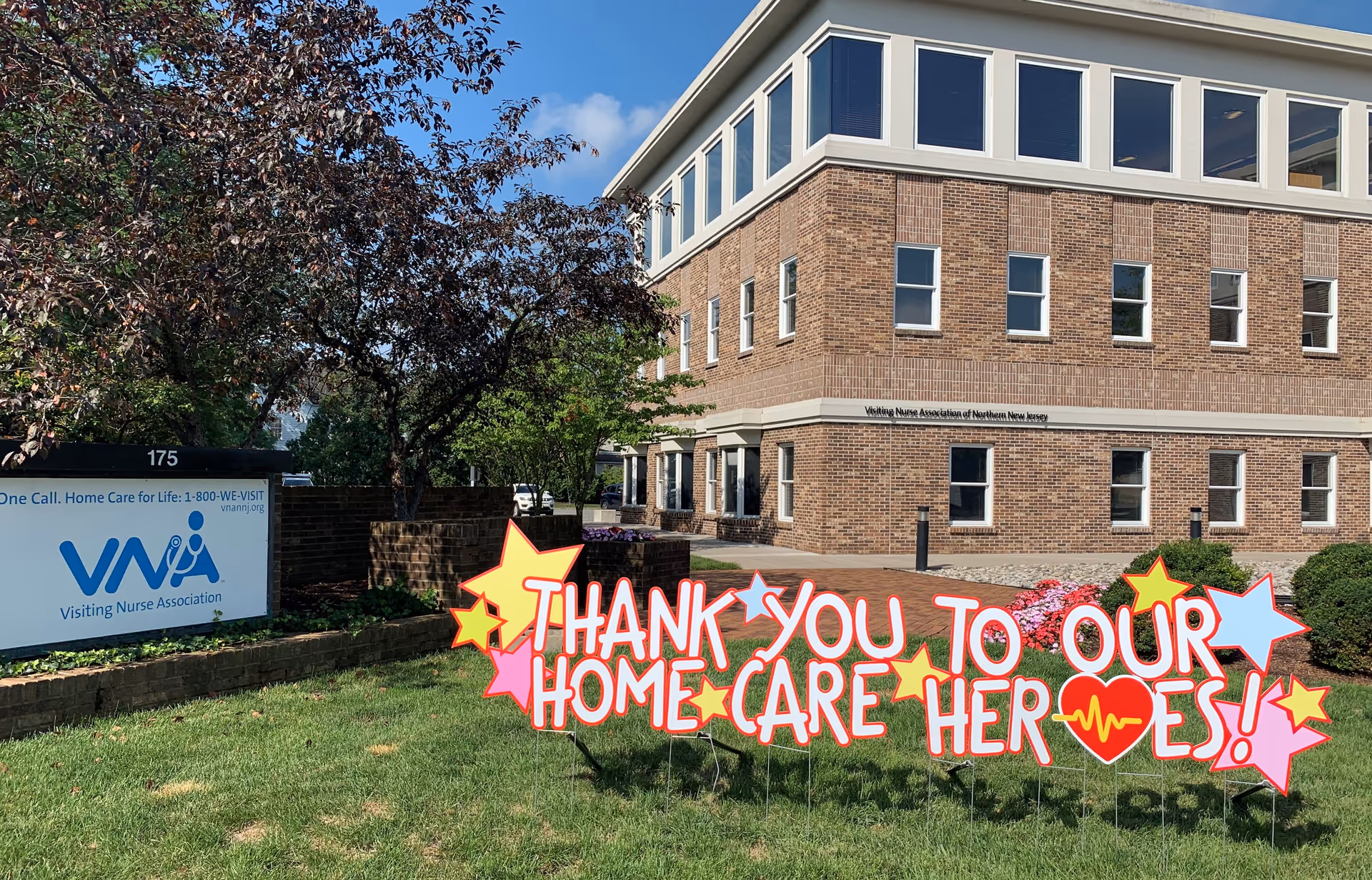Exterior view of a brick building with a colorful outdoor sign thanking home care heroes