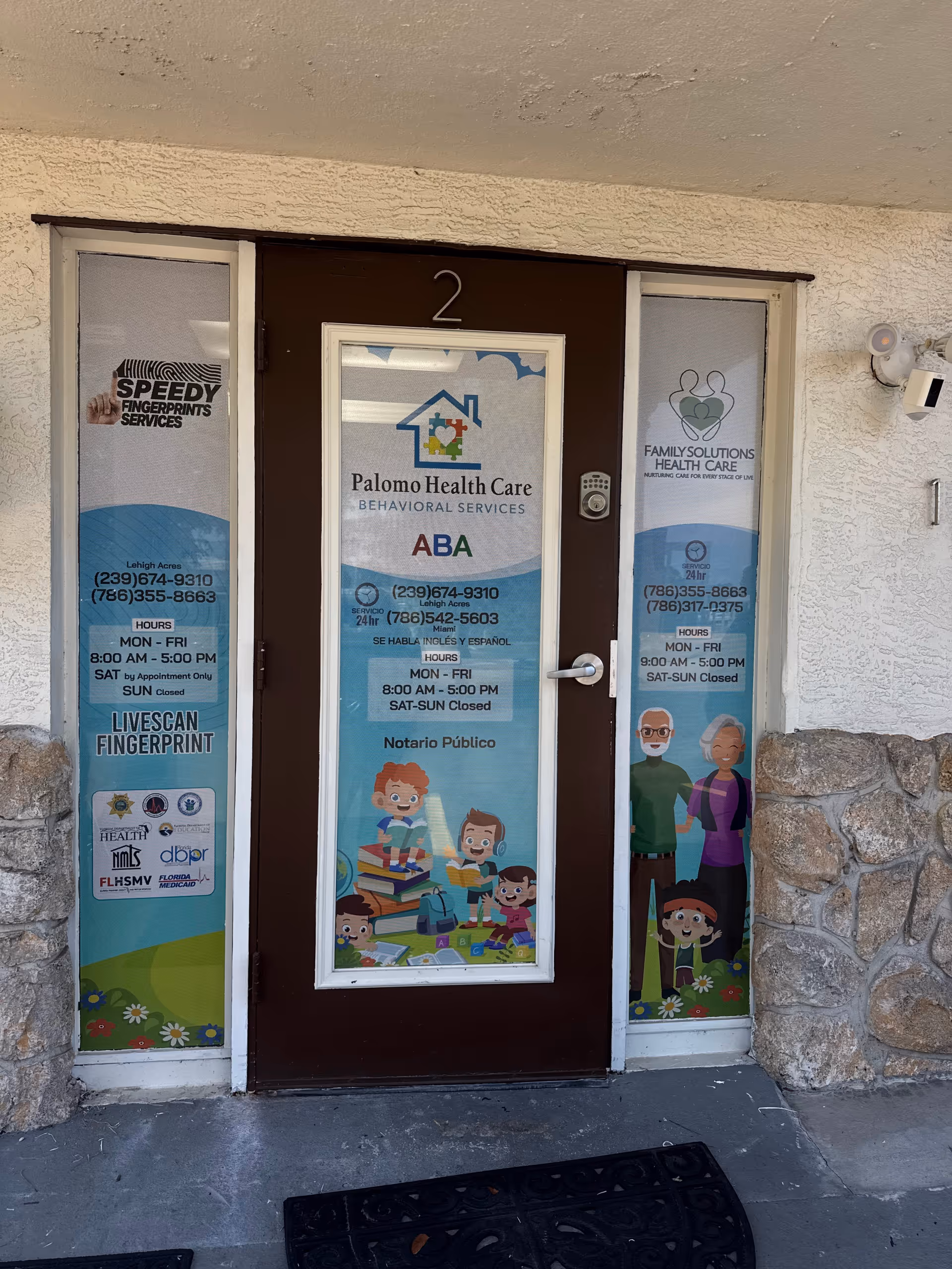 Front entrance of Palomo Health Care with glass doors and banners.
