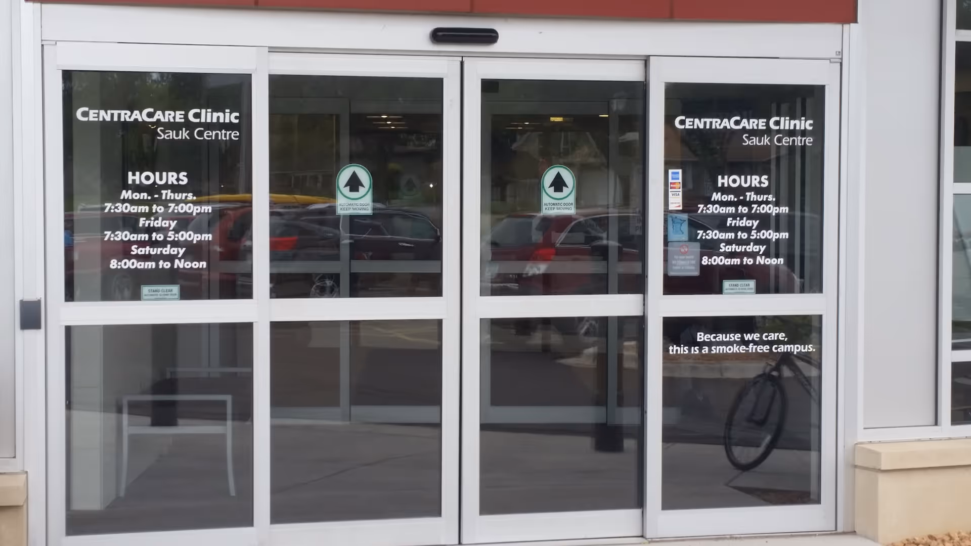 Glass entrance doors of CentraCare Clinic Sauk Centre with posted hours.