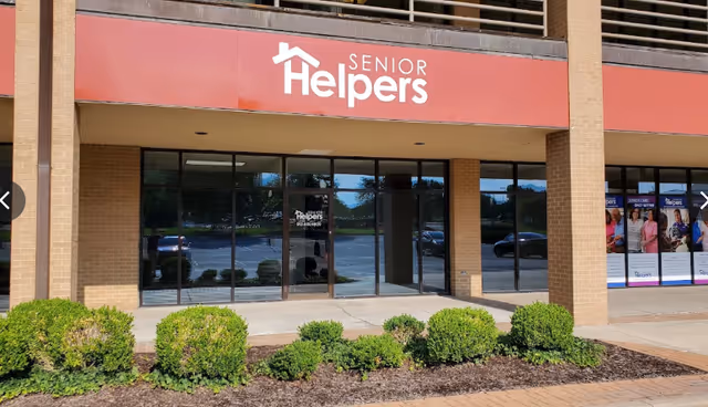 Front exterior of Senior Helpers of Johnson County with red sign and glass doors.