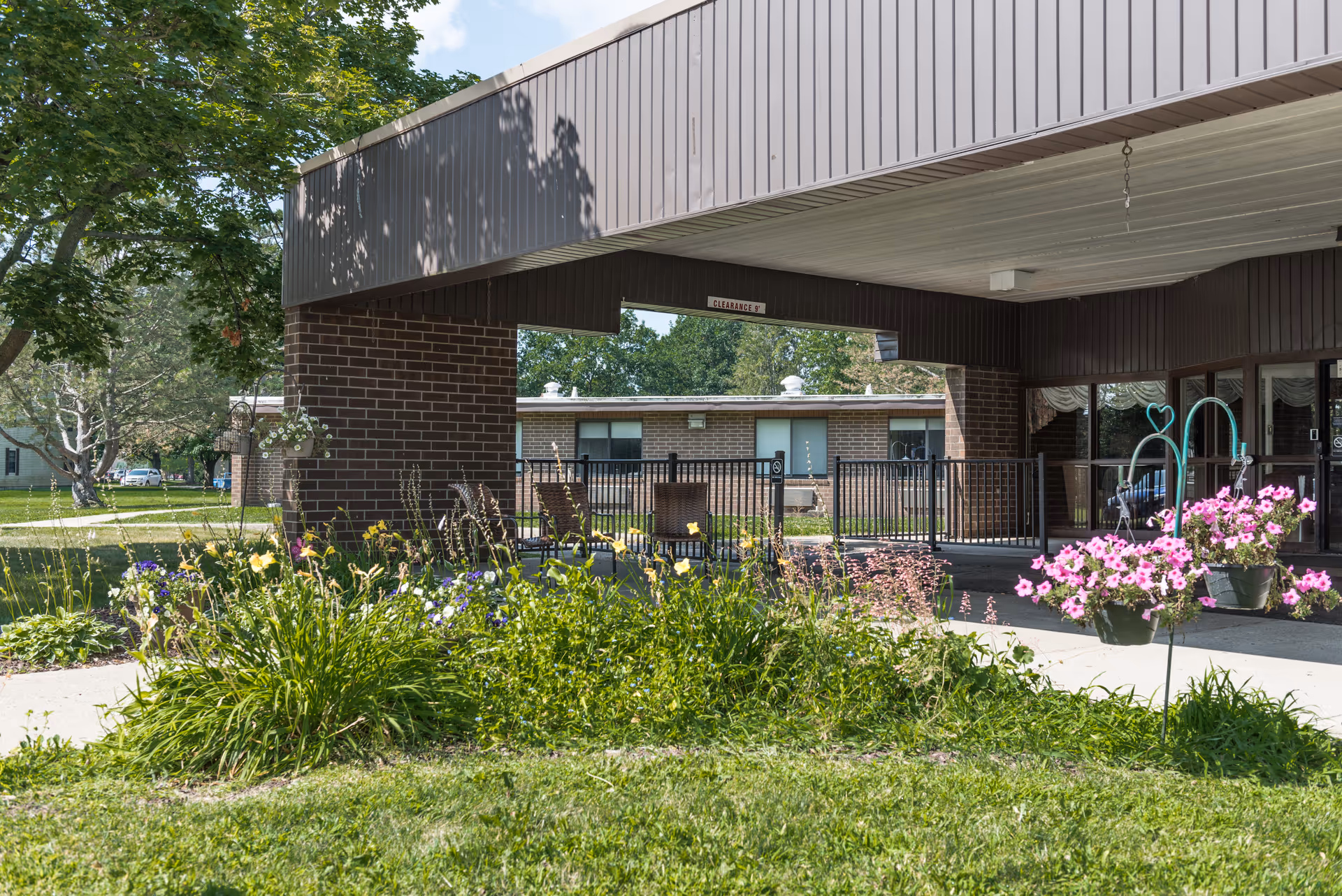 Exterior of Heartland Health Care Center-Three Rivers with garden, walkway, and seating.