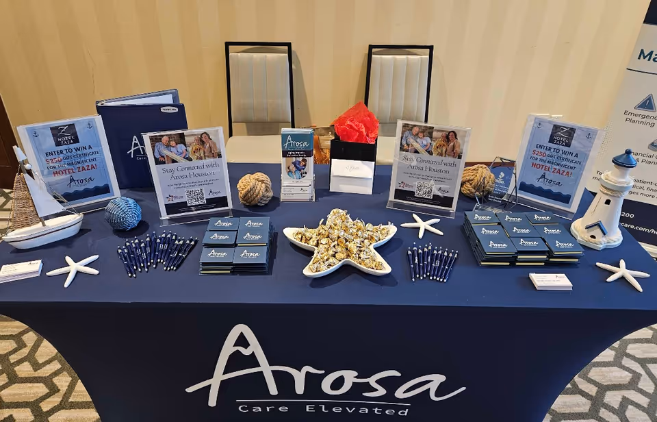 Indoor display table for Arosa Houston with brochures, pens, signs, and sea themed decor.
