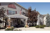 Exterior view of Orchard Place Senior Apartments entrance with awning and landscaping.