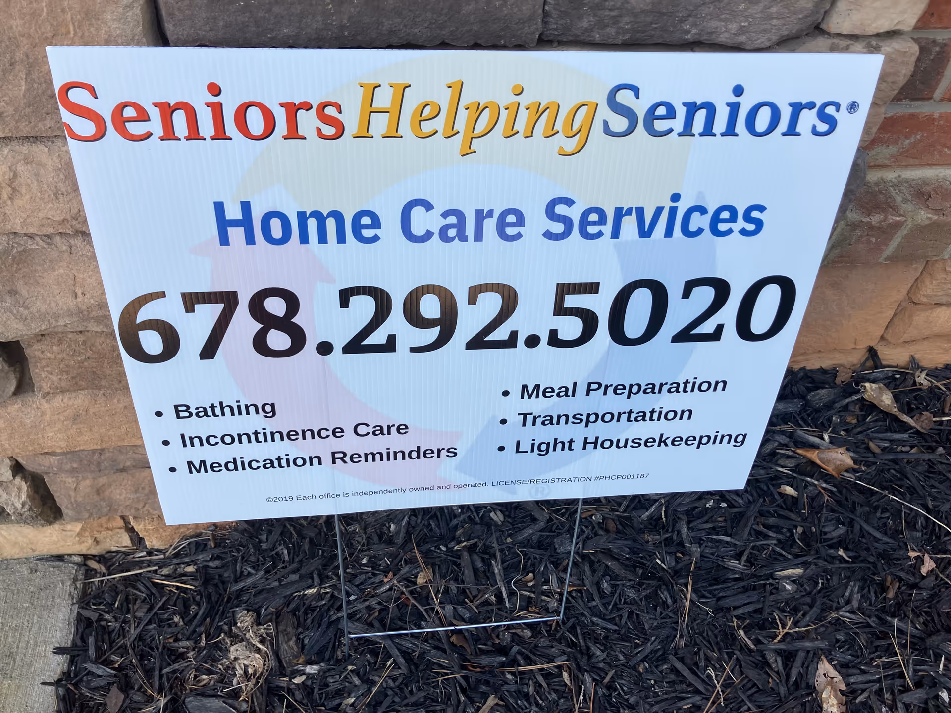 Outdoor sign advertising Seniors Helping Seniors Athens Home Care Services with contact number