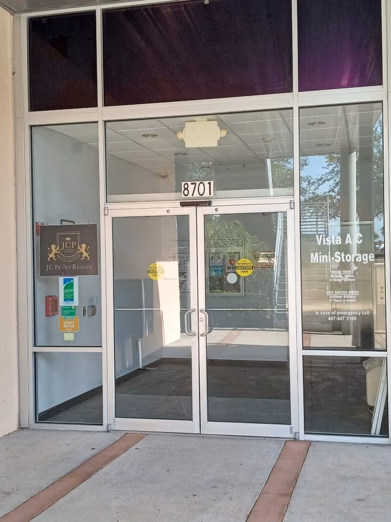 Glass storefront entrance with double doors and the number 8701.