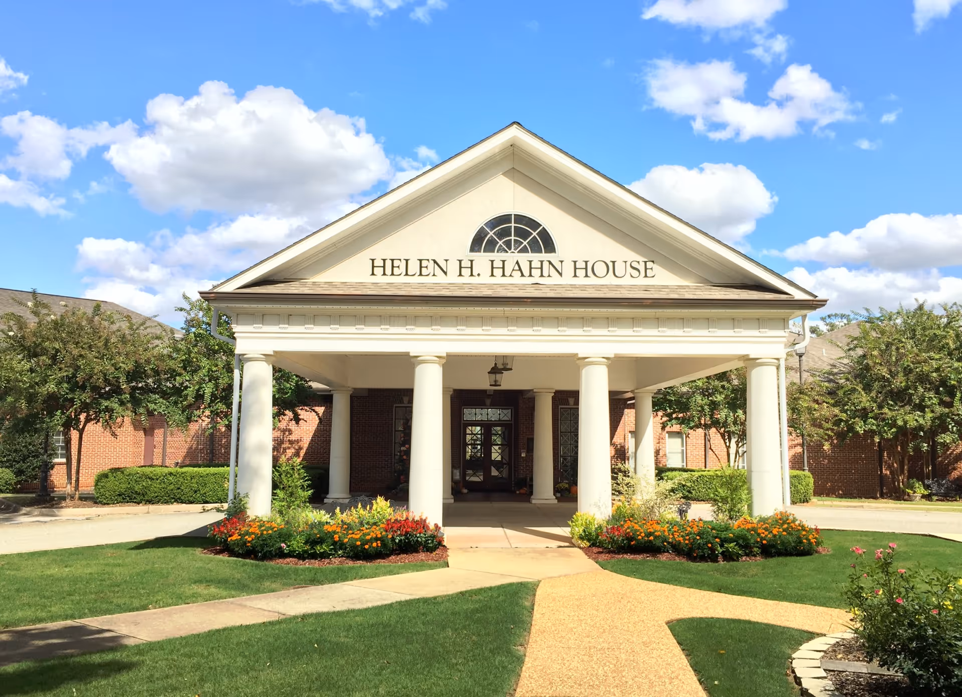 Front entrance of Helen H. Hahn House hospice with columns and landscaped walkway.