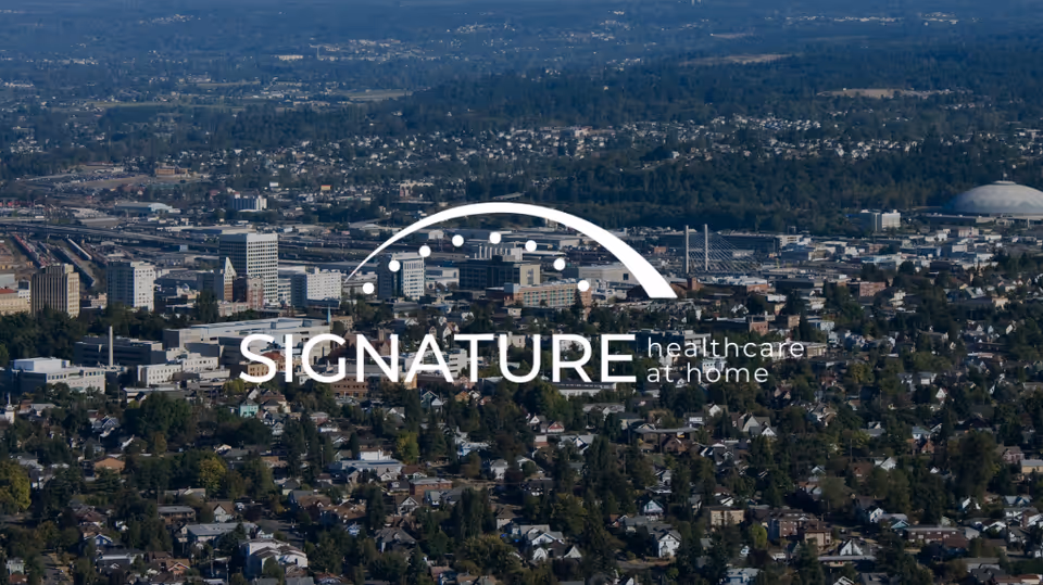 Aerial cityscape with Signature healthcare at home watermark across center.
