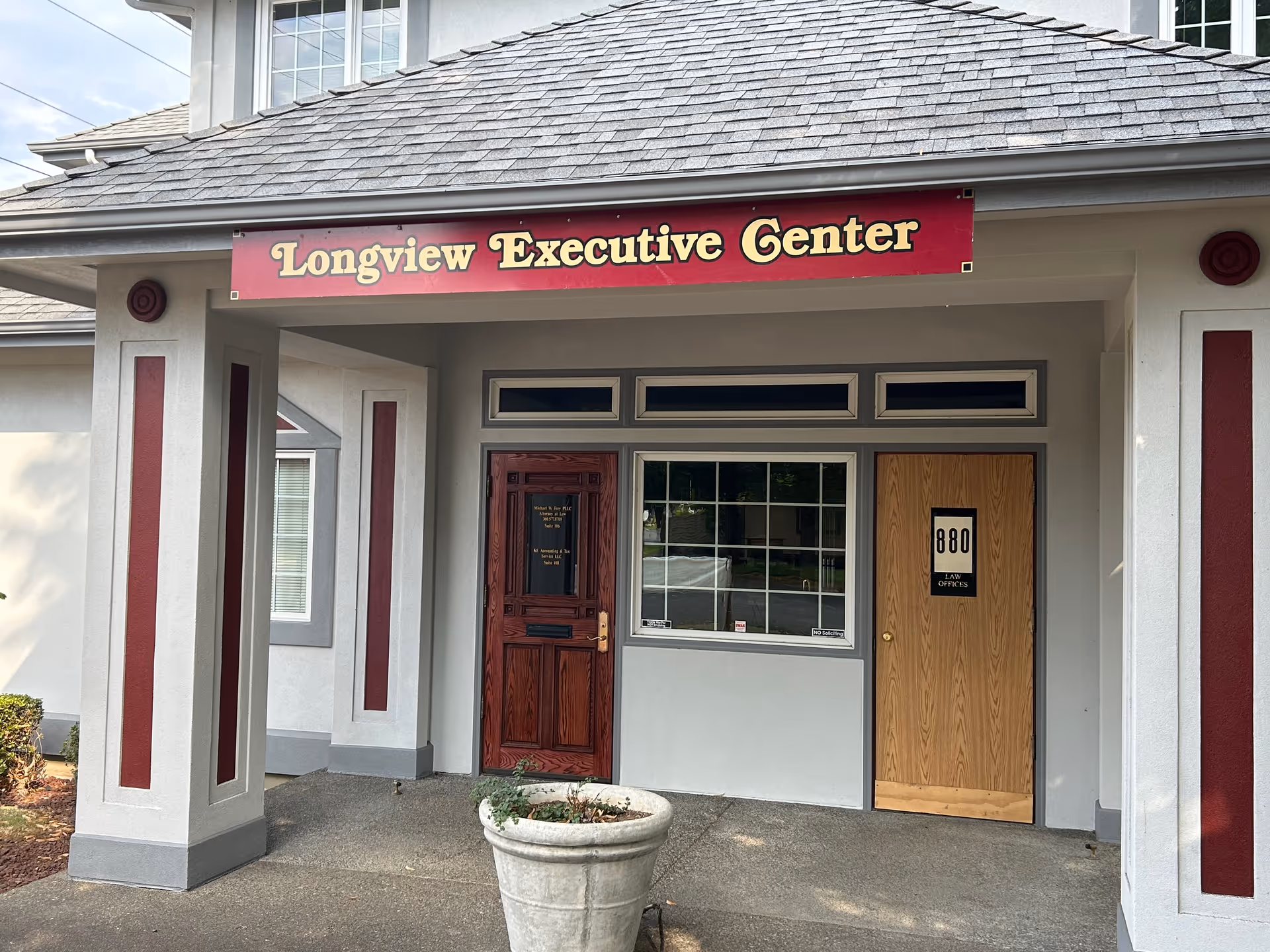 Facade of a building with a Longview Executive Center sign and two entry doors.